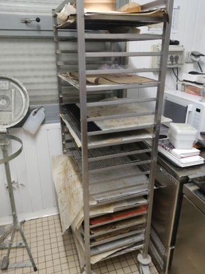 de nombreux plateaux de nourriture posés sur une étagère métallique dans une cuisine