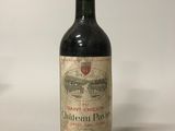 une bouteille de vin rouge posée sur une table blanche