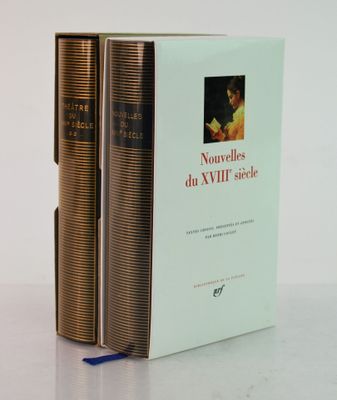 two books sitting on top of each other on a white surface