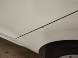 a close up of a white car with a black stripe on it