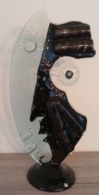 a glass sculpture of a man ' s face on a stand