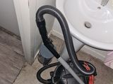 un aspirateur posé par terre à côté d'un évier