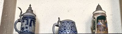 trois vases bleus et blancs posés sur une étagère près d'un mur blanc