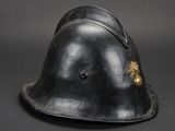 an old black helmet with a gold emblem on the side of it