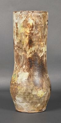 a vase that is sitting on a table in front of a gray background
