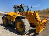 un tracteur jaune garé sur la terre battue