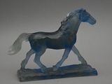 a blue horse figurine that is standing on a table