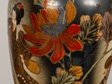 a vase with a floral design on it sitting on a table