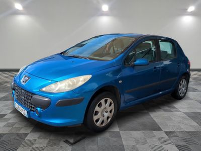 une voiture bleue est garée dans une pièce au sol à carreaux