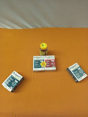 un lit recouvert d'un drap orange, sur lequel sont posés quelques livres