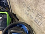 a blue and green vacuum sitting next to a wall