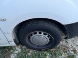 a white van with a flat tire parked on the side of the road