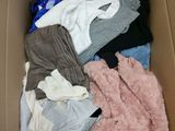 a cardboard box filled with clothes and a teddy bear