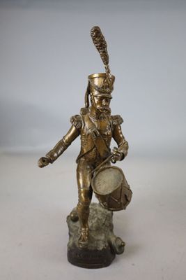 figurine en laiton représentant un soldat tenant un tambour, posée sur un socle