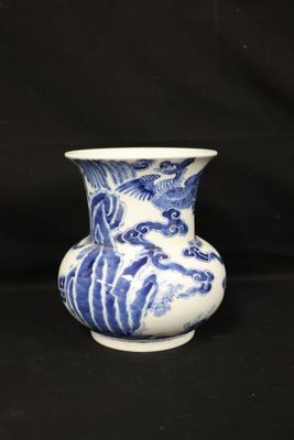 a blue and white vase sitting on a black surface