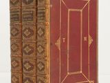 two old books sitting on top of each other on a white surface