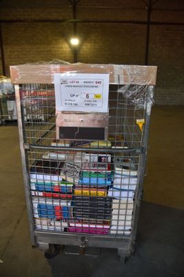 un chariot rempli de livres dans un entrepôt, surmonté d'une pancarte
