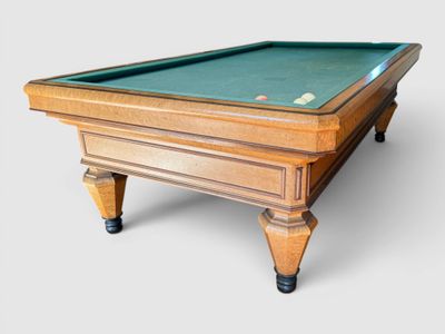 the pool table is made of wood and has a green cloth