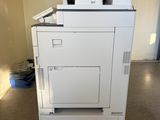 a white printer sitting on top of a cart in a room