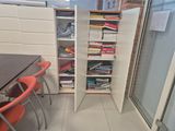 a tall cabinet with many books on it in a room
