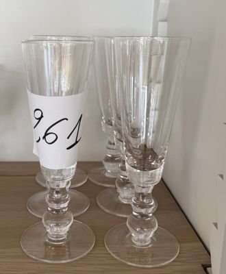 quatre verres à vin vides posés sur une table en bois