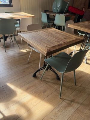 de nombreuses chaises et tables dans une pièce au sol en parquet