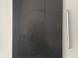 a tablet computer sitting on a table with a pen next to it