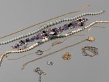 many necklaces and bracelets laid out on a table