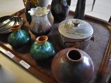 many vases on a tray that are on a table