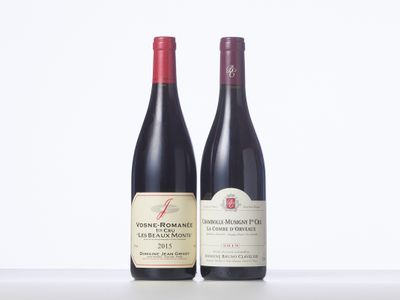 two bottles of red wine sitting next to each other on a table