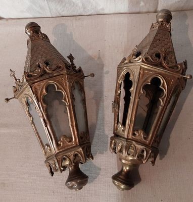 une paire de lanternes anciennes en laiton posées sur une nappe blanche