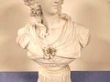 une statue représentant une femme avec une fleur dans les cheveux