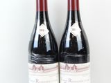deux bouteilles de vin rouge posées l'une à côté de l'autre sur une surface blanche