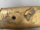 a gold object with a bird on it on a table