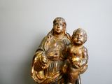 une statue de femme tenant un enfant sur une table