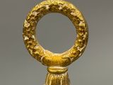 an image of a close up of a gold object with a ring on it