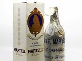 an old bottle of wine sitting next to a box on a white surface