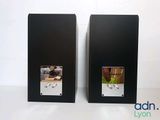 pair of black speakers with pictures on them on a white surface