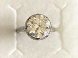 une photo d'une bague en diamant posée dans une boîte blanche