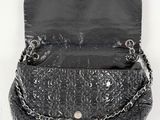 black leather purse with chain and clasps on a white background