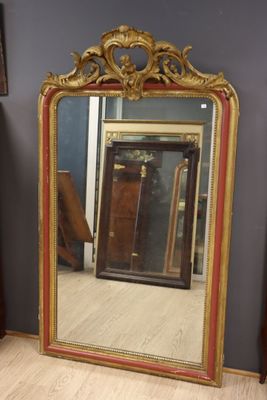 Important miroir en bois sculpté doré rechampi rouge, le fro…