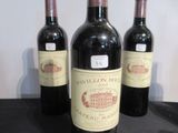 trois bouteilles de vin sont alignées sur un plan de travail