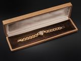 a close up of a watch in a wooden box on a black background