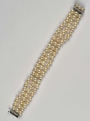 a close up of a bracelet with pearls on it