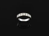 a white gold and diamond ring on a black surface
