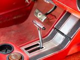 a close up of a red car dashboard with a steering control