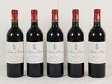 quatre bouteilles de vin rouge sont alignées sur une surface blanche