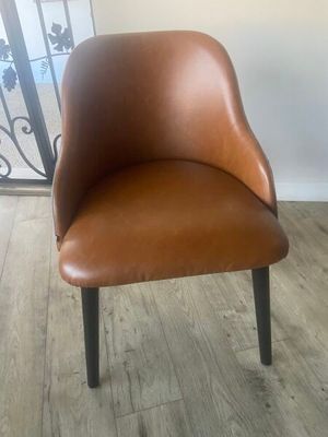 a brown chair that is sitting on a wooden floor