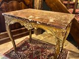 a table with a marble top on a rug in a room