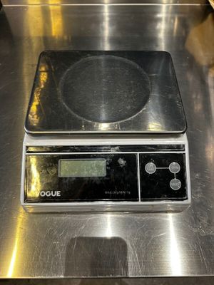 une balance numérique posée sur un comptoir en métal